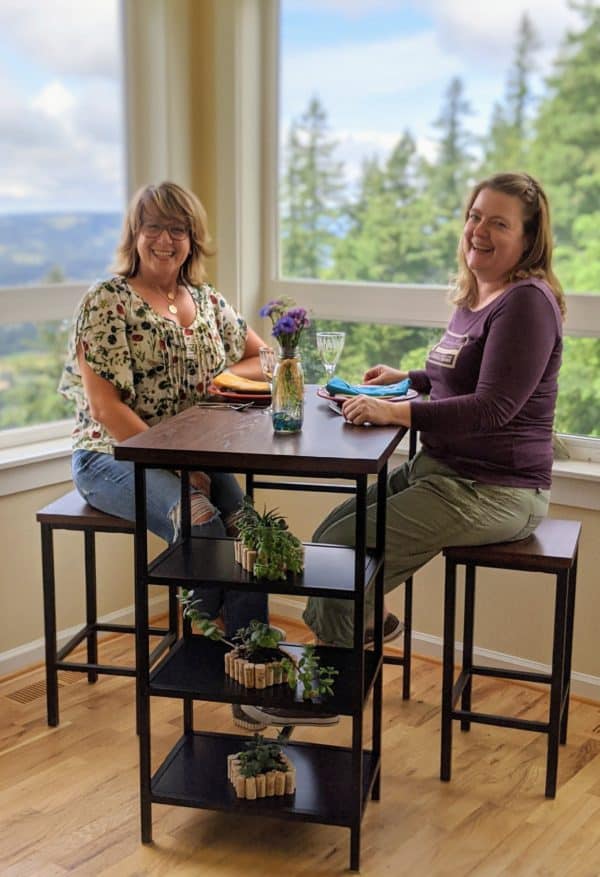Two women sitting at a tall table
