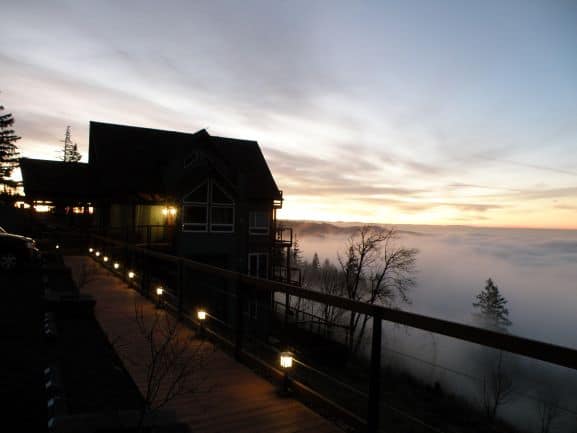 a house at dusk above a fog bank