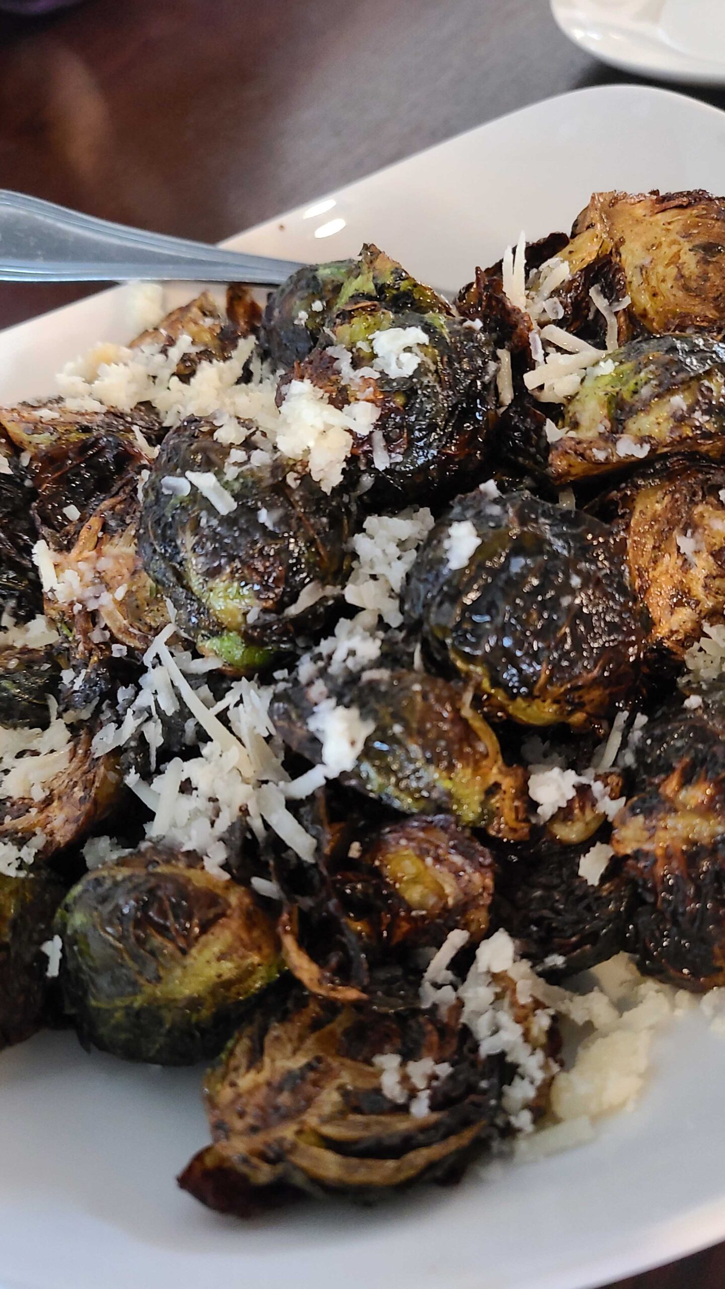 A plate of deep fried brussels sprouts with parmesan cheese