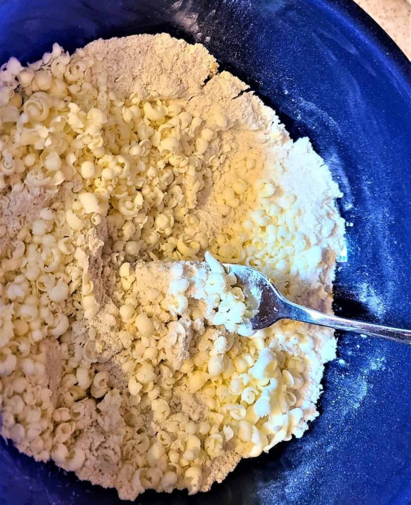 a blue bowl with gluten-free flour and butter pieces with a fork