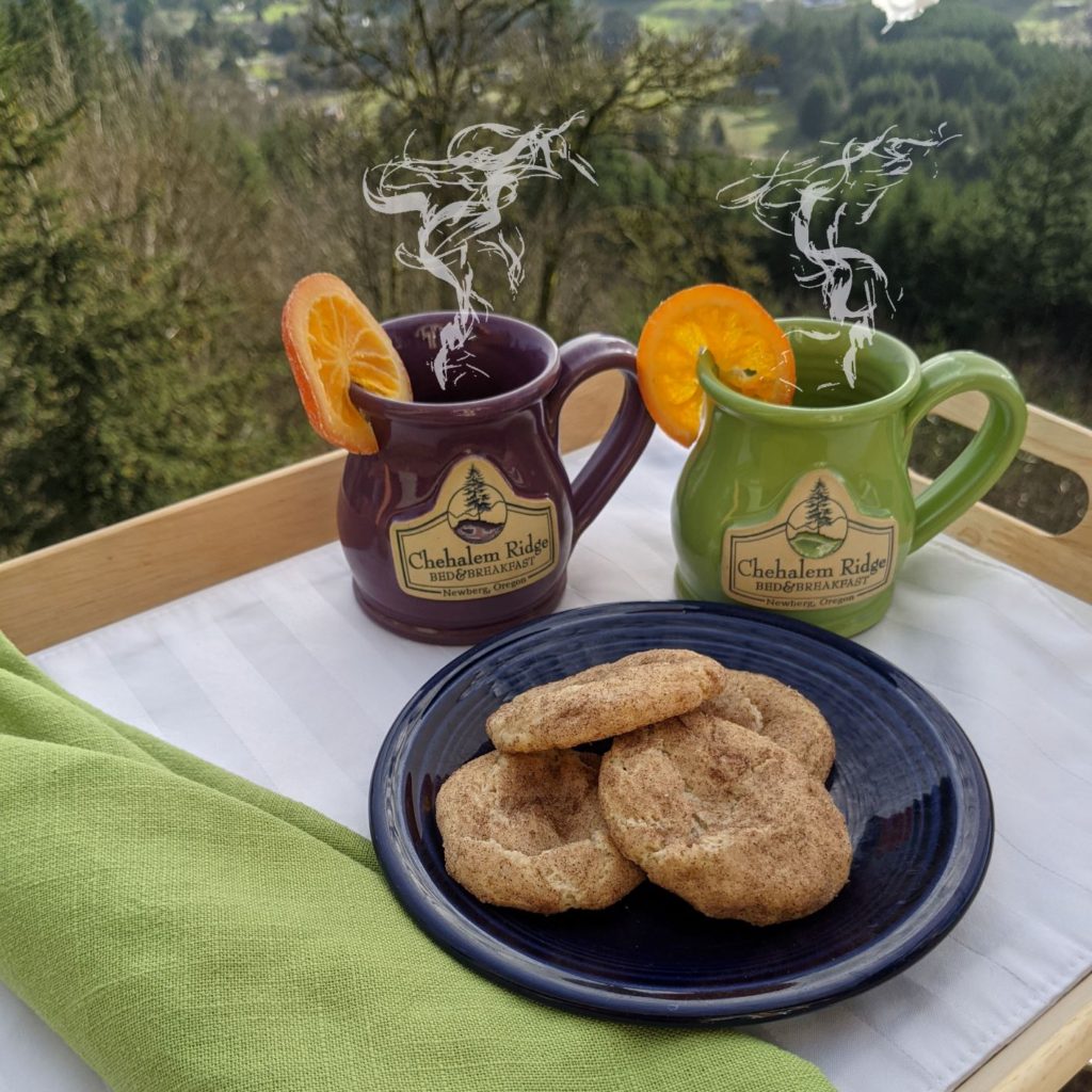 a tray with two mugs, a plate of 4 snickerdoodle cookies and napkins