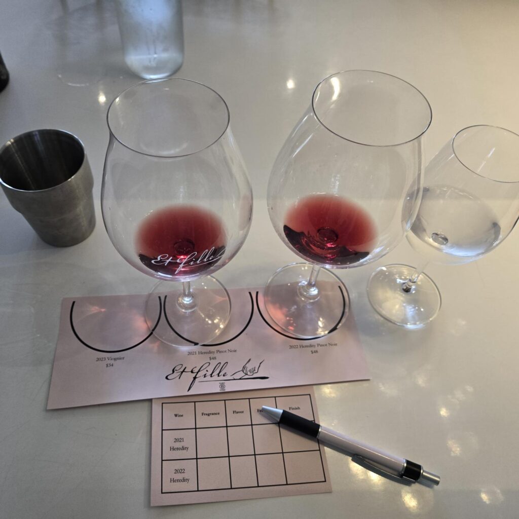 Two glasses of wine on top of a card labeling them as 2021 and 2022 vintages of Et Fille Wines