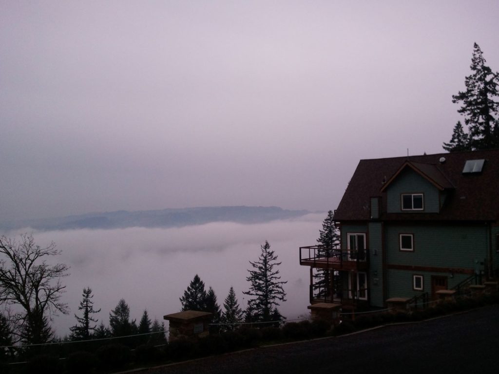 a house on a hill with fog covering the willamette valley below