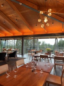 a large room in a Willamette Valley winery with tables set for wine tasting and large windows towards the back