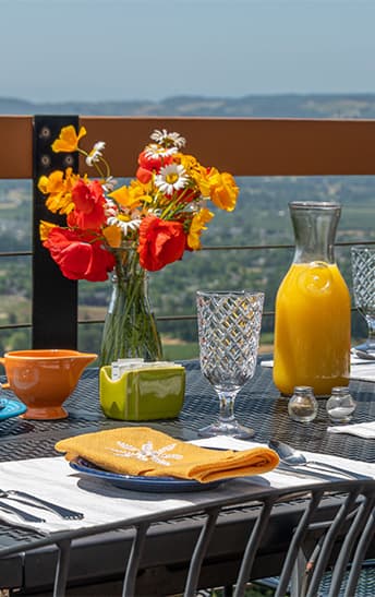Outdoor table set for breakfast with flowers