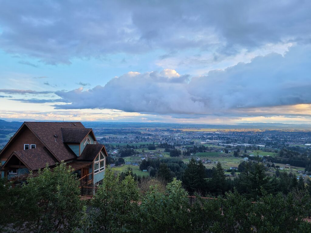 The Chehalem Ridge B &B building with a view of the valley below, clouds in the sky
