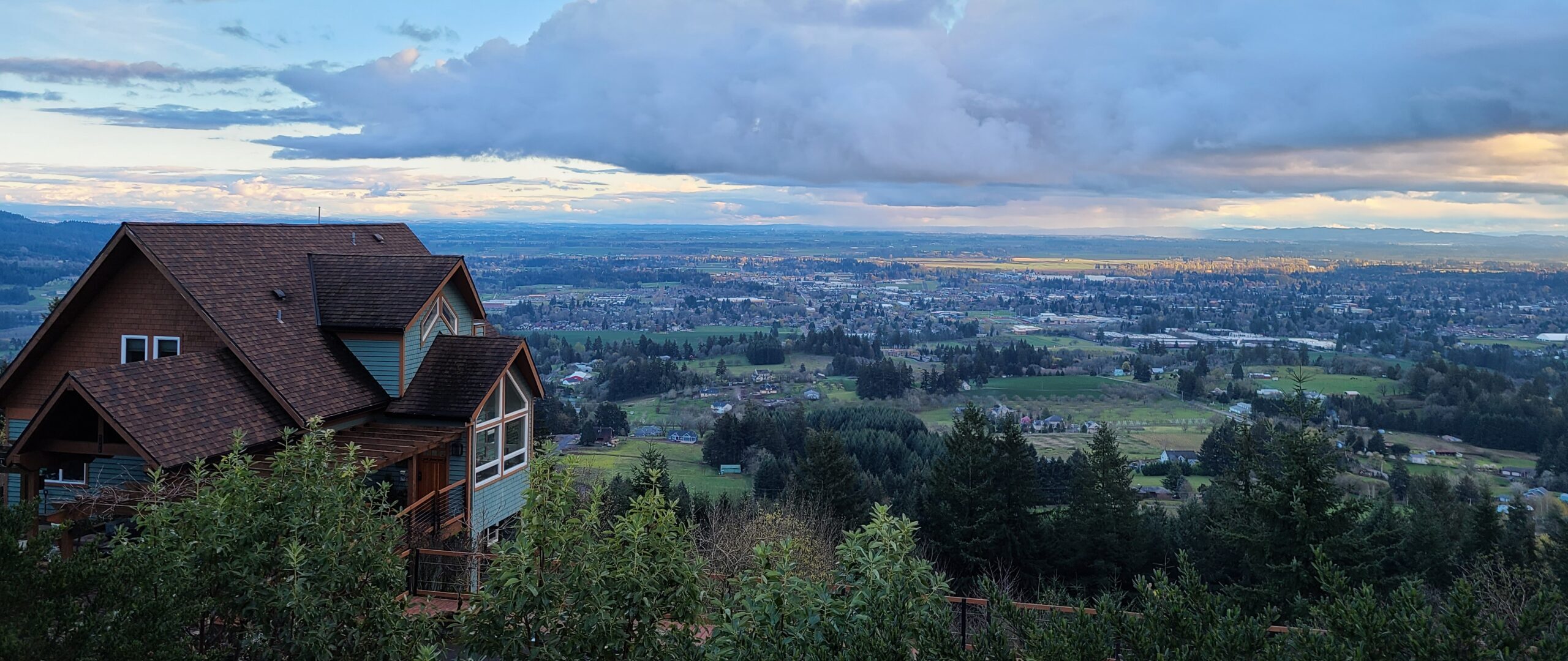 The Chehalem Ridge B &B building with a view of the valley below, clouds in the sky